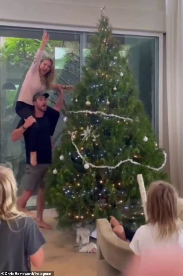 Elsa manages to place the star on top of the tree, to the cheers of the family members